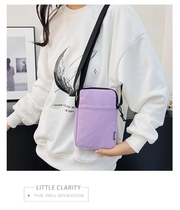 Close-up of a light purple canvas crossbody phone bag with adjustable black strap