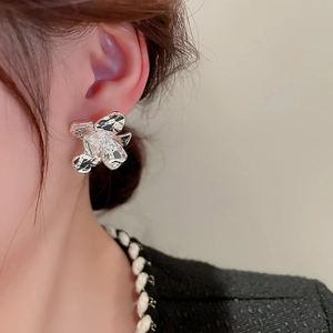 Chic silver floral metal earrings with irregular wrinkled texture on a female model