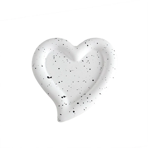 Minimalist white heart-shaped ceramic tray with black speckled pattern for jewelry storage