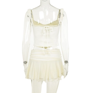 Rear view of white two-piece set featuring backless camisole and ruffled mini skirt