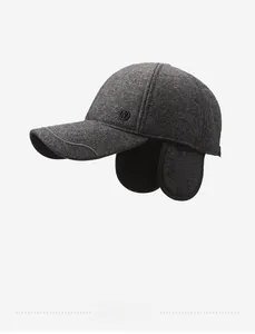 Detail view of winter baseball cap with ear flaps and side logo in dark grey knit