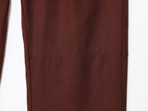 Detail of dark brown-red pants showing high-quality double stitching and canvas texture