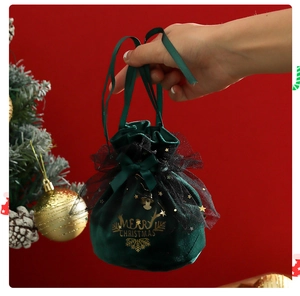 Detail of green velvet Christmas drawstring bag with gold lettering and black mesh bow