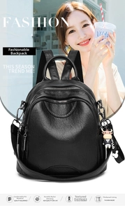 Detail of soft black PU leather backpack with cartoon charm and multi-zipper pockets