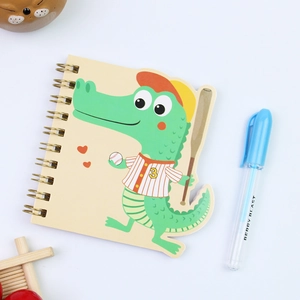 Detail of a mini spiral notebook featuring a cute green crocodile cartoon on the cover