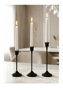 Juego de tres candelabros de hierro negro mate con velas blancas sobre mármol
