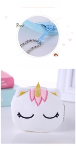 Detail of plush unicorn coin purse featuring embroidered eyes and metal bead chain