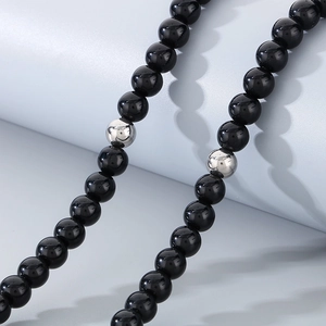 Close-up of 8mm black onyx beads with silver metal spacers on a minimalist necklace