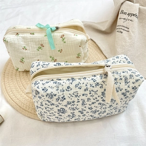 Detail of floral quilted cotton makeup bags with delicate ribbon zipper and soft texture