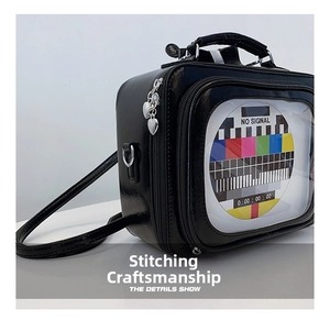 Detailed macro view of the retro TV shaped crossbody bag with heart-shaped metal pendants