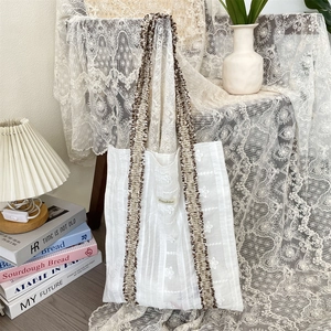Détail de la broderie florale et de la sangle tissée sur le sac cabas en toile