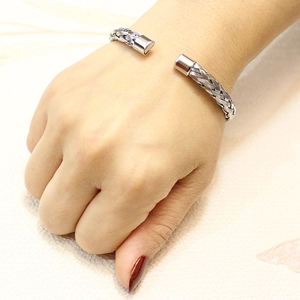 Detail of silver braided stainless steel cuff bracelet on wrist with smooth end caps