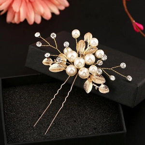 Elegant gold bridal hair pin with white pearls, rhinestones, and metal leaves
