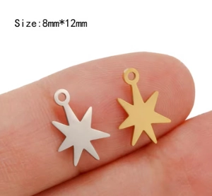 Macro view of gold and silver stainless steel star charms held on finger to show 8x12mm size