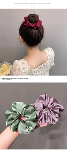 Detail view of satin scrunchies in burgundy, green and purple with silk texture and gloss