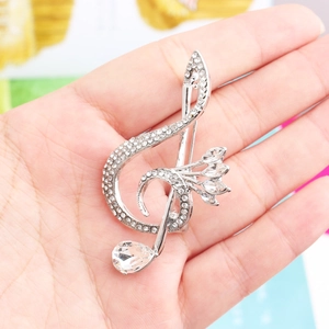 Macro shot of a music note brooch with inlaid crystals and teardrop rhinestone detail