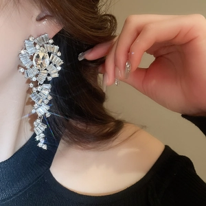 Détail macro d'un mannequin portant des boucles d'oreilles géométriques en diamant argent