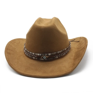 Détail d'un chapeau de cowboy en daim marron avec pendentif ethnique œil protecteur