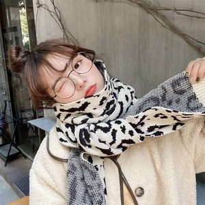 Detailed view of knitted scarf with leopard and houndstooth patterns on a winter coat