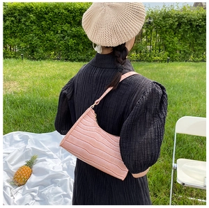 Pink crocodile pattern baguette bag shown in a stylish outdoor picnic setting