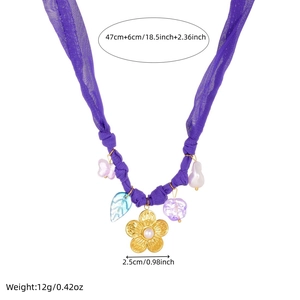 Detailed view of floral necklace showing purple fabric chain and gold-plated flower pendant