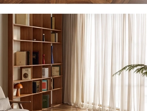 Modern home office view featuring a large wooden bookshelf with books by a sunlit window
