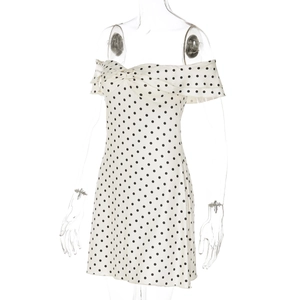 Detail shot of white off-the-shoulder dress with black polka dots on a mannequin