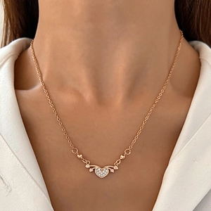 Close-up of rose gold heart necklace with micro-set zircons on female model's neck