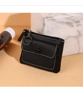 Detail of black PU leather coin purse with white stitching, zipper, and key ring