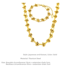 Détail macro de l'ensemble collier et bracelet à maillons noués en acier titane doré poli