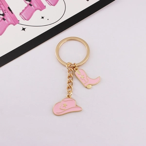 Detailed view of pink western cowboy hat and boot keychain with golden alloy hardware