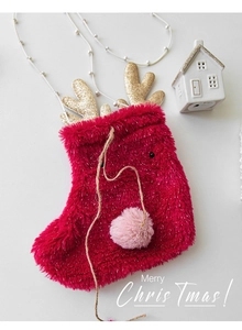 Detail of red plush Christmas stocking with gold glitter antlers and a pink pompom