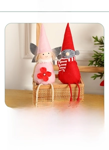 Détail d'une poupée ange de Noël en peluche avec de longues jambes et une écharpe rayée