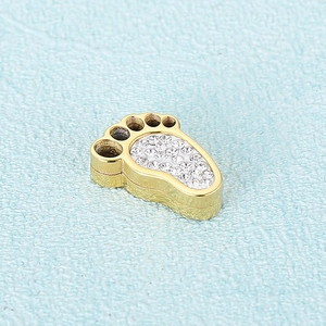 Golden footprint pendant with clear rhinestones on a textured light blue background
