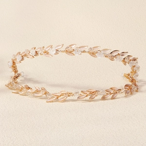 Close-up of bridal headband with golden leaves, white flowers and pearl accents