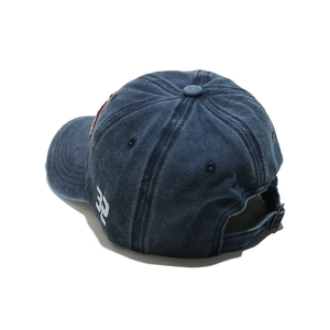 Detail view of washed denim baseball cap with adjustable metal buckle and side embroidery