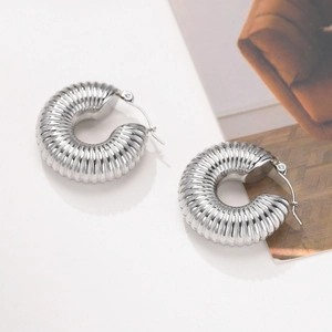 Close-up of silver-tone hollow C-shaped hoop earrings with textured ribbed design