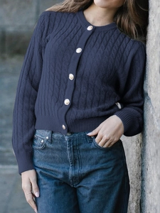 Detailed cable knit texture on women's navy blue crewneck cardigan with metal buttons