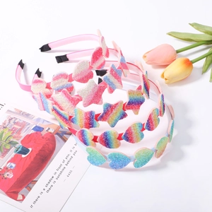 Detailed view of children's glitter star and heart headbands in rainbow gradient colors
