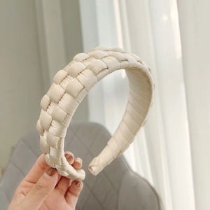 Detailed close-up of handmade cream braided wide headband with silky woven texture