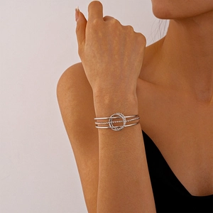 Detail of silver triple-layered geometric cuff bracelet with twisted rope texture on wrist