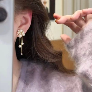 Elegant floral pearl tassel earrings in gold finish worn by model with violet sweater