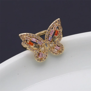 Macro shot of gold-plated butterfly ring with colorful rectangular gems and micro-pave crystals