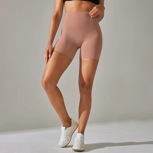 Macro detail of high-waist yoga shorts showing matte pink seamless fabric and stitching