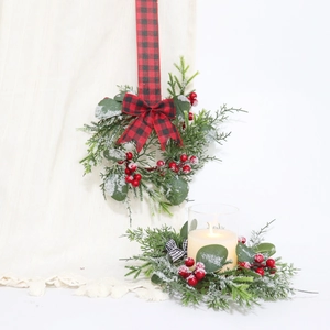 Close-up of snowy mini Christmas wreath with eucalyptus, red berries and plaid bow detail