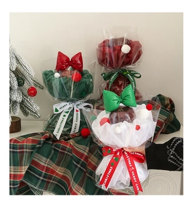 Close-up of Christmas themed candy house gift wrap with Merry Christmas ribbons and bows
