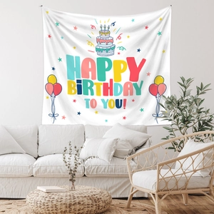 Close-up of bohemian Happy Birthday tapestry with cake and balloon patterns