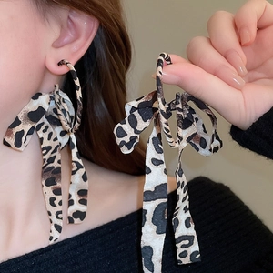 Détail de boucles d'oreilles nœud léopard avec anneau en métal sur modèle