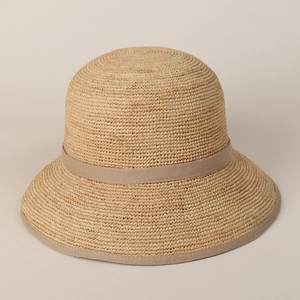 Detailed close-up of natural raffia straw weaving and elegant ribbon edge on sun hat