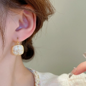 Detail of vintage square enamel earring with star zircon on a model's ear
